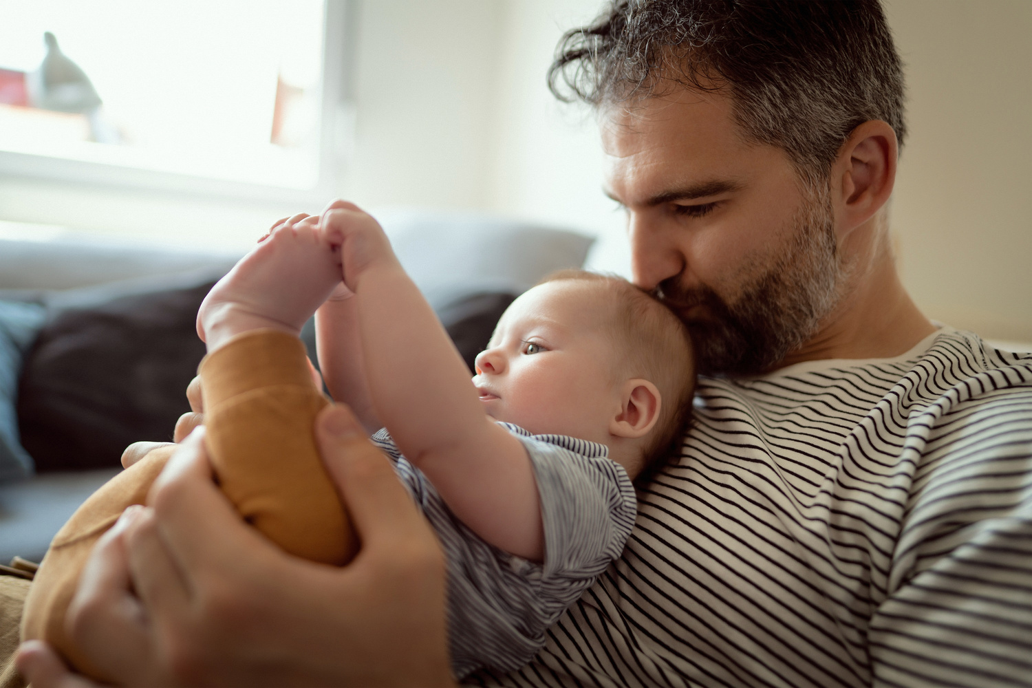 Humana zusammen wachsen Papa kuschelt Baby greift Füße