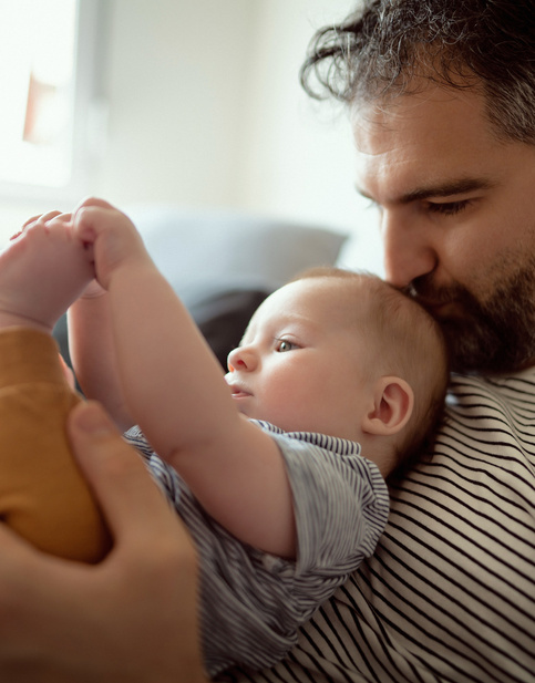 Humana zusammen wachsen Papa kuschelt Baby greift Füße